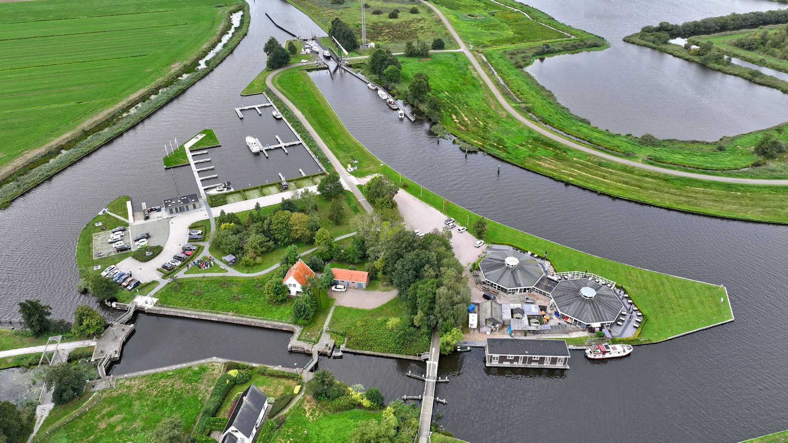 Luchtfoto van de Driewegsluis in Nijetrijne, met de sluis, jachthaven, vaarwegen, wandel- en fietspaden en het omliggende groene landschap.
